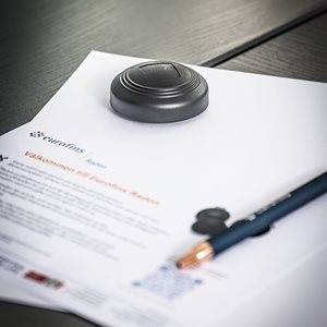 Informationsblad från Eurofins med detektor och penna på ett bord
