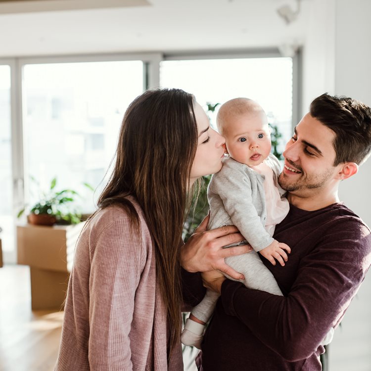 Ung familj med bebis i ny bostad med ljus inomhusmiljö